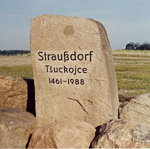 Ein gespaltener Findling mit der Inschrift: Straußdorf 1461-1988