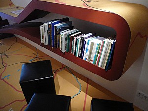 Ein Bücherregal und Sitzmöglichkeiten der Leseecke werden gezeigt.