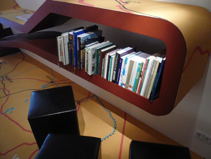Foto: Ein Bücherregal und Sitzmöglichkeiten der Leseecke werden gezeigt.