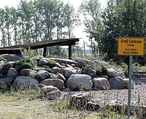 Blick zur umgesetzten Schutzhütte mit Ortseingangsschild Groß Lieskow