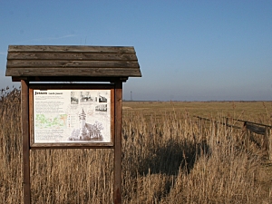 Gedenktafel am Wegesrand vor einer großen Koppel