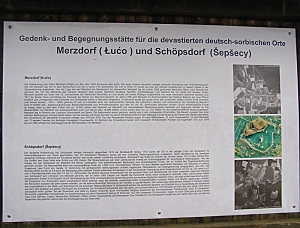Blick auf die Gedenktafel mit Texten und Luftbildern zu Merzdorf und Schöpsdorf Blick auf die Gedenktafel mit Texten und Luftbildern zu Merzdorf und Schöpsdorf