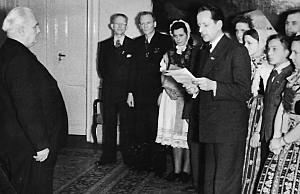 Trachtenträgerinnen und einige Männer stehen Wilhelm Pieck gegenüber. Trachtenträgerinnen und einige Männer stehen Wilhelm Pieck gegenüber.